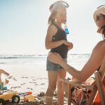 Best After-Sun Lotions for Beach Vacations Shot of an adorable little girl bonding with her mother at the beach
