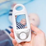 Hand holding video baby monitor for security of the baby